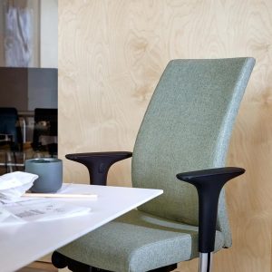 HÅG HÅG Creed 6006 green upholstered office chair with black armrests at white desk in modern office setting
